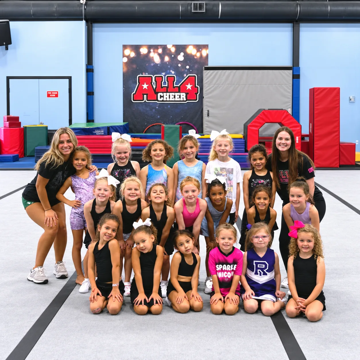 Young athletes and coaches posing together in the All 4 Prosper gym.